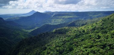 Panoramic view of rolling green mountains and forest valleys under a cloudy sky